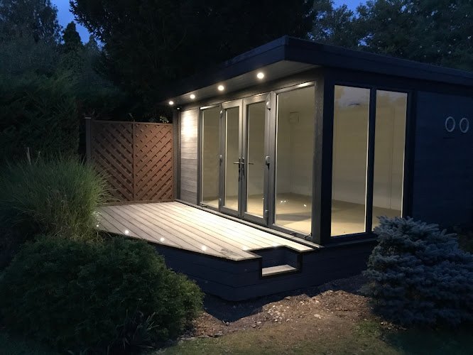 Lit up summer house with small decking area